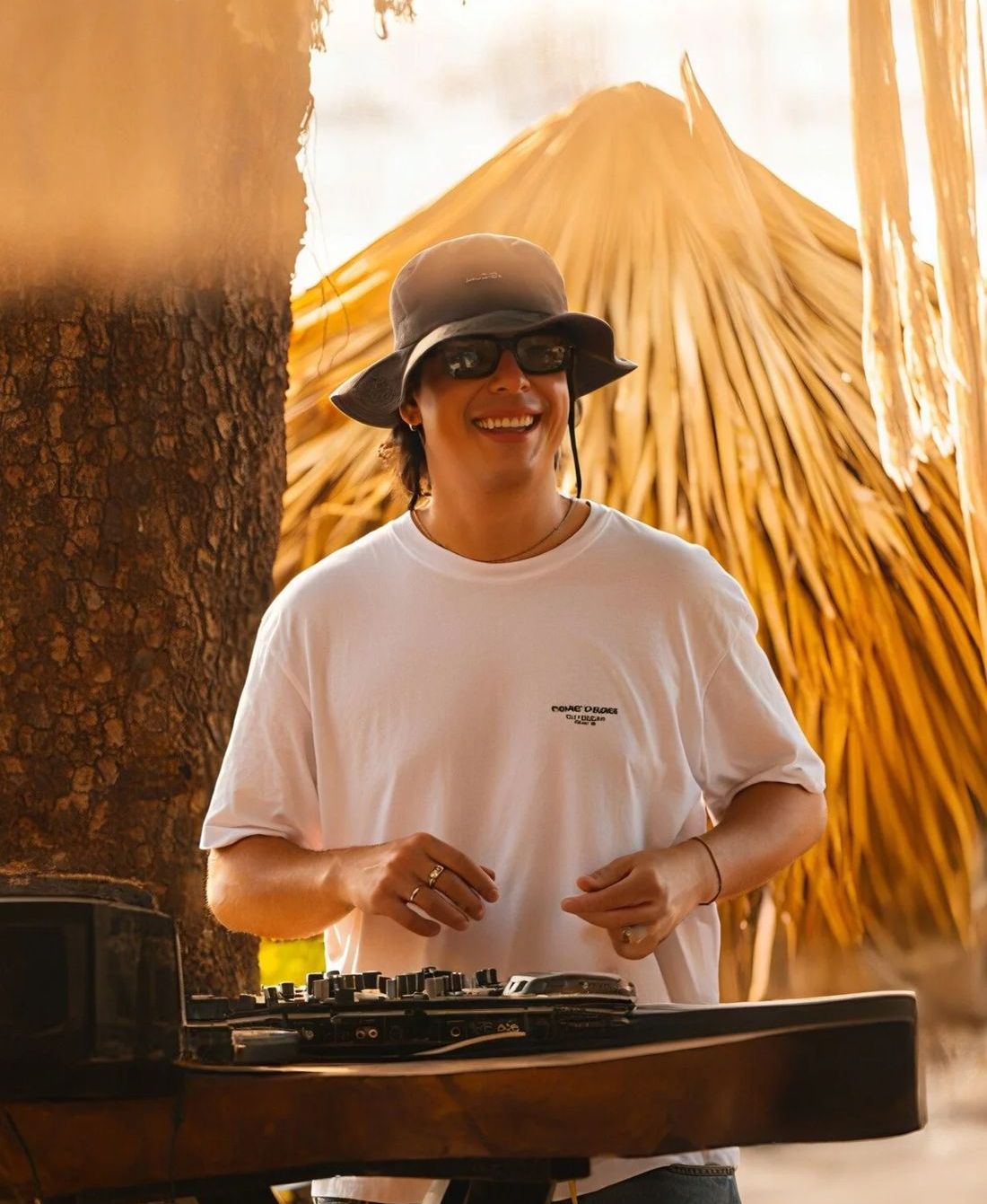 DJ Párraga smiling during a sunset beach DJ set in Guanacaste, Costa Rica