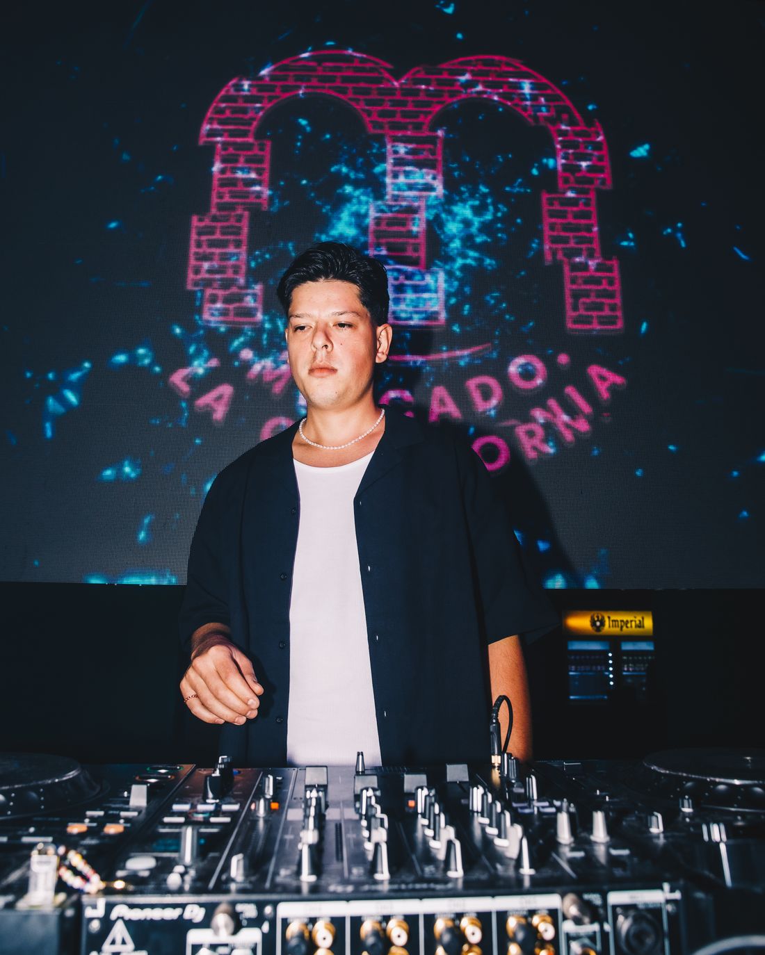 Portrait of DJ Párraga behind the decks at a club event in Costa Rica